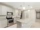 Modern kitchen with stainless appliances and a large center island with bar stool seating at 9822 W Caron Dr, Peoria, AZ 85345