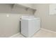 Laundry room with white washer and dryer and open shelving for ample storage at 9822 W Caron Dr, Peoria, AZ 85345