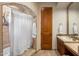 Elegant bathroom features a tiled shower with a white curtain and a vanity with a travertine countertop at 10511 E Skinner Dr, Scottsdale, AZ 85262