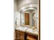 Bathroom featuring travertine countertops, a wooden door, and a decorative mirror at 10511 E Skinner Dr, Scottsdale, AZ 85262