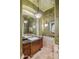 Stylish powder bathroom with a decorative mirror, sconces, and a granite countertop vanity at 10511 E Skinner Dr, Scottsdale, AZ 85262