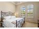 Comfortable bedroom with neutral colors, iron bed frame, plush carpet, and arched windows with shutters at 10511 E Skinner Dr, Scottsdale, AZ 85262