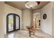 Grand foyer with intricate iron doors, high ceilings, and a decorative table that welcomes guests at 10511 E Skinner Dr, Scottsdale, AZ 85262