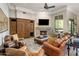 Cozy living room with a stone fireplace, built-in shelving, and large windows overlooking the garden at 10511 E Skinner Dr, Scottsdale, AZ 85262