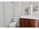 Bright bathroom with white tile floors and a toilet next to a dark wood vanity at 11142 E Ravenna Ave, Mesa, AZ 85212