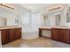 Primary bathroom with soaking tub, glass block window and dual vanities at 11142 E Ravenna Ave, Mesa, AZ 85212
