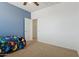 Bedroom featuring carpeted floor, blue accent wall, and a doorway at 11142 E Ravenna Ave, Mesa, AZ 85212