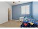 Bedroom featuring carpeted floor, blue accent wall, and a window at 11142 E Ravenna Ave, Mesa, AZ 85212
