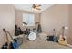 Bedroom featuring neutral walls, ceiling fan, window with blinds and musical instruments at 11142 E Ravenna Ave, Mesa, AZ 85212