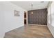 Open-concept dining room featuring wood-style floors and stylish accent wall at 11142 E Ravenna Ave, Mesa, AZ 85212