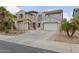 Elegant two-story house features a spacious driveway leading to an attached two-car garage and mature palm trees at 11142 E Ravenna Ave, Mesa, AZ 85212