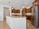 Bright kitchen with granite counters, tile floors, stainless steel refrigerator and modern pendant lighting at 11142 E Ravenna Ave, Mesa, AZ 85212