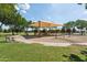 Community playground with swings and slides surrounded by trees at 11142 E Ravenna Ave, Mesa, AZ 85212