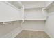 Walk-in closet with carpeted floor and multiple white shelves and clothes rods at 11142 E Ravenna Ave, Mesa, AZ 85212