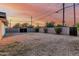 Backyard featuring a low-maintenance gravel landscape, enclosed by a block fence and bordered by mature shrubs at 1258 E Campus Dr, Tempe, AZ 85282
