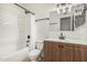Bathroom featuring a shower-tub combo, with updated fixtures and a wood vanity cabinet for additional storage at 1258 E Campus Dr, Tempe, AZ 85282