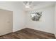 Cozy bedroom featuring wood flooring, neutral walls, and natural light from the window and ceiling fan to complete the space at 1258 E Campus Dr, Tempe, AZ 85282
