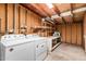 Unfinished laundry room features a washer, dryer, storage shelving and workspace, providing functionality and practicality at 1258 E Campus Dr, Tempe, AZ 85282