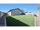 The spacious backyard features a seating area and artificial grass at 13487 W Buckskin Trl, Peoria, AZ 85383