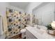 Bright bathroom with a floral shower curtain, a large mirror and modern fixtures at 13487 W Buckskin Trl, Peoria, AZ 85383