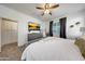 Bedroom with a ceiling fan, neutral carpet, television, and a large walk-in closet at 13487 W Buckskin Trl, Peoria, AZ 85383