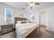 Light-filled bedroom featuring neutral carpet, a wood-stained bed frame, and a ceiling fan at 13487 W Buckskin Trl, Peoria, AZ 85383