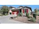 Attractive home with a well-maintained front yard, desert landscaping, and a bright red garage door at 13487 W Buckskin Trl, Peoria, AZ 85383