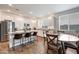 Bright kitchen with white cabinets, granite countertops, stainless steel appliances, and a breakfast bar at 13487 W Buckskin Trl, Peoria, AZ 85383