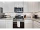 Modern kitchen with stainless steel appliances, white cabinetry, and granite countertops at 13487 W Buckskin Trl, Peoria, AZ 85383