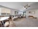 Inviting living room with large sectional sofa, carpet flooring, and a ceiling fan at 13487 W Buckskin Trl, Peoria, AZ 85383