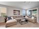 Comfortable living room featuring a spacious sectional sofa, neutral tones, and ample natural light at 13487 W Buckskin Trl, Peoria, AZ 85383