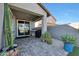 View of a covered patio area with pavers, featuring a grill, cactus, and other plants at 13487 W Buckskin Trl, Peoria, AZ 85383