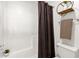 A clean, white bathroom with tiled shower, decorative shelf, and neutral accents at 13636 N Saguaro Blvd # 103, Fountain Hills, AZ 85268