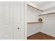 Walk-in closet with wood shelving, wood floors and white paneled door at 13636 N Saguaro Blvd # 103, Fountain Hills, AZ 85268