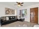 Cozy living room features a sleek black leather sofa and neutral tile flooring at 13636 N Saguaro Blvd # 103, Fountain Hills, AZ 85268