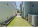 Narrow backyard with artificial turf, a grill, and an AC unit at 1482 S Banning St, Gilbert, AZ 85296