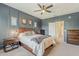 Beautiful bedroom featuring an accent wall, ceiling fan, and adjacent bathroom at 1482 S Banning St, Gilbert, AZ 85296