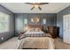 Comfortable bedroom featuring a ceiling fan, wall decor, carpet and wooden bed frame with lots of pillows at 1482 S Banning St, Gilbert, AZ 85296
