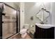 Well-lit bathroom with a glass-enclosed shower, vanity sink, toilet and decorative mirror at 15407 W Windrose Dr, Surprise, AZ 85379