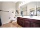 Bathroom featuring a double sink vanity, tile floors, and a large mirror at 15407 W Windrose Dr, Surprise, AZ 85379