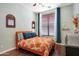 Inviting bedroom with a brightly patterned bedspread, wood floors and an open window at 15407 W Windrose Dr, Surprise, AZ 85379