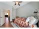 Comfortable bedroom with wood floors, ceiling fan, and access to another room at 15407 W Windrose Dr, Surprise, AZ 85379