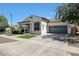 Well-maintained single-story home with a gray garage door, landscaped front yard, and tile roof at 15407 W Windrose Dr, Surprise, AZ 85379
