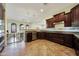 Bright kitchen with dark cabinets, stainless steel appliances, and open layout to a dining area at 15407 W Windrose Dr, Surprise, AZ 85379