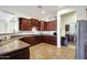 Spacious kitchen featuring granite countertops, dark wood cabinets, and stainless steel appliances at 15407 W Windrose Dr, Surprise, AZ 85379