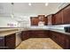 Spacious kitchen with dark wood cabinetry, stainless steel appliances, granite countertops and tile backsplash at 15407 W Windrose Dr, Surprise, AZ 85379