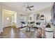 Bright living room featuring a ceiling fan, tile flooring, and ample natural light at 15407 W Windrose Dr, Surprise, AZ 85379