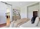 Bright main bedroom featuring a barn door to ensuite and a neutral color palette at 15407 W Windrose Dr, Surprise, AZ 85379