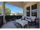 Relaxing covered patio with comfortable seating, decorative rug, and view of the neighborhood at 15407 W Windrose Dr, Surprise, AZ 85379