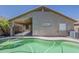 A refreshing backyard pool with covered patio, a unique kidney shape and an air conditioning unit at 15905 W Saguaro Ln, Surprise, AZ 85374